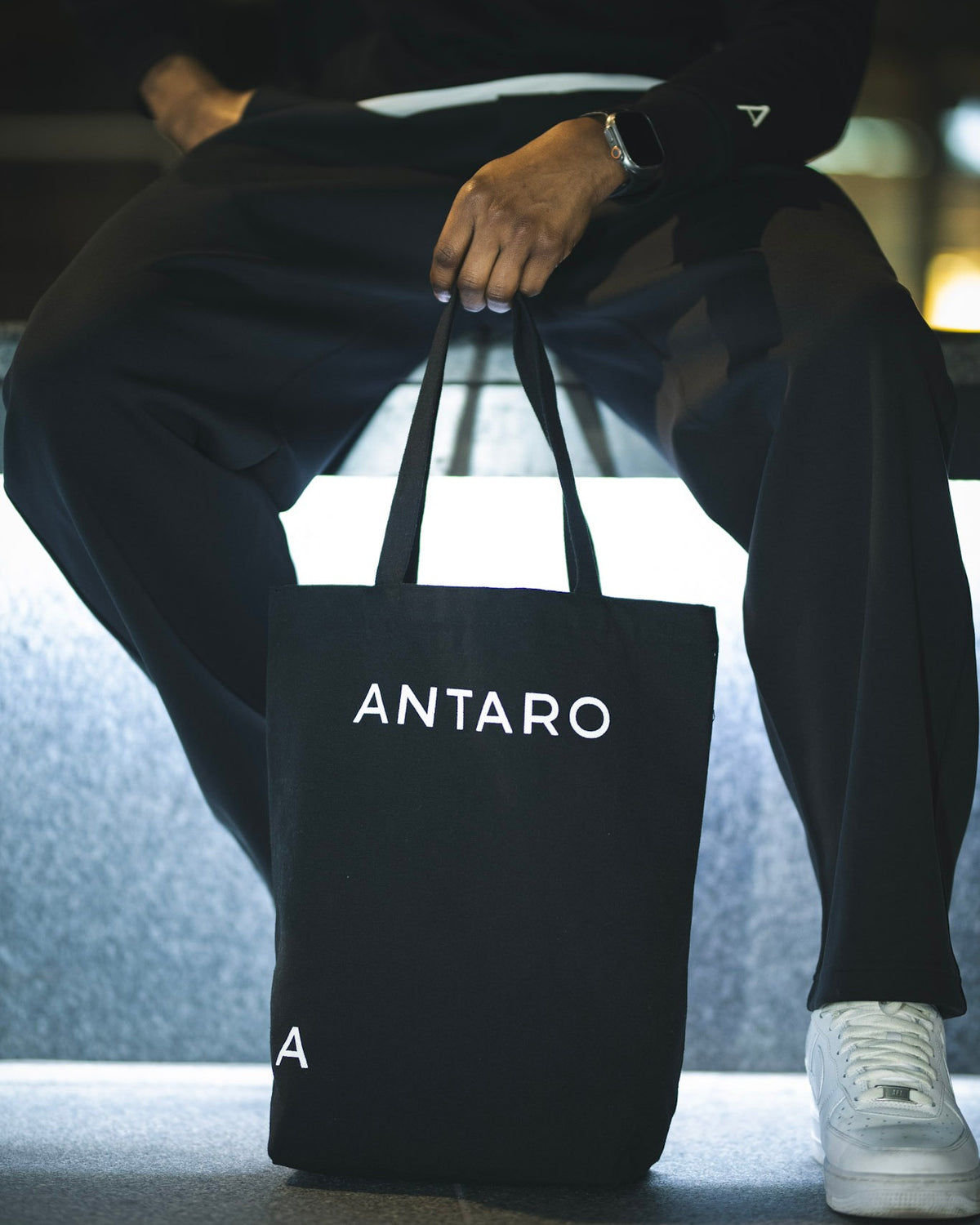 The ANTARO Everyday Tote in black, held while seated