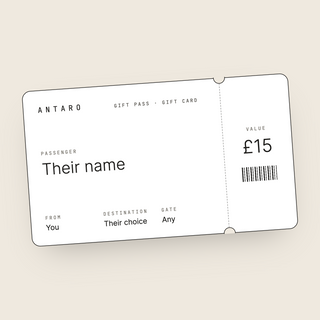 The ANTARO Gift Pass: a white boarding-pass style gift card with a black edge on a cream background, showing Passenger, From, Destination and Gate, and a tear-off stub with the value.