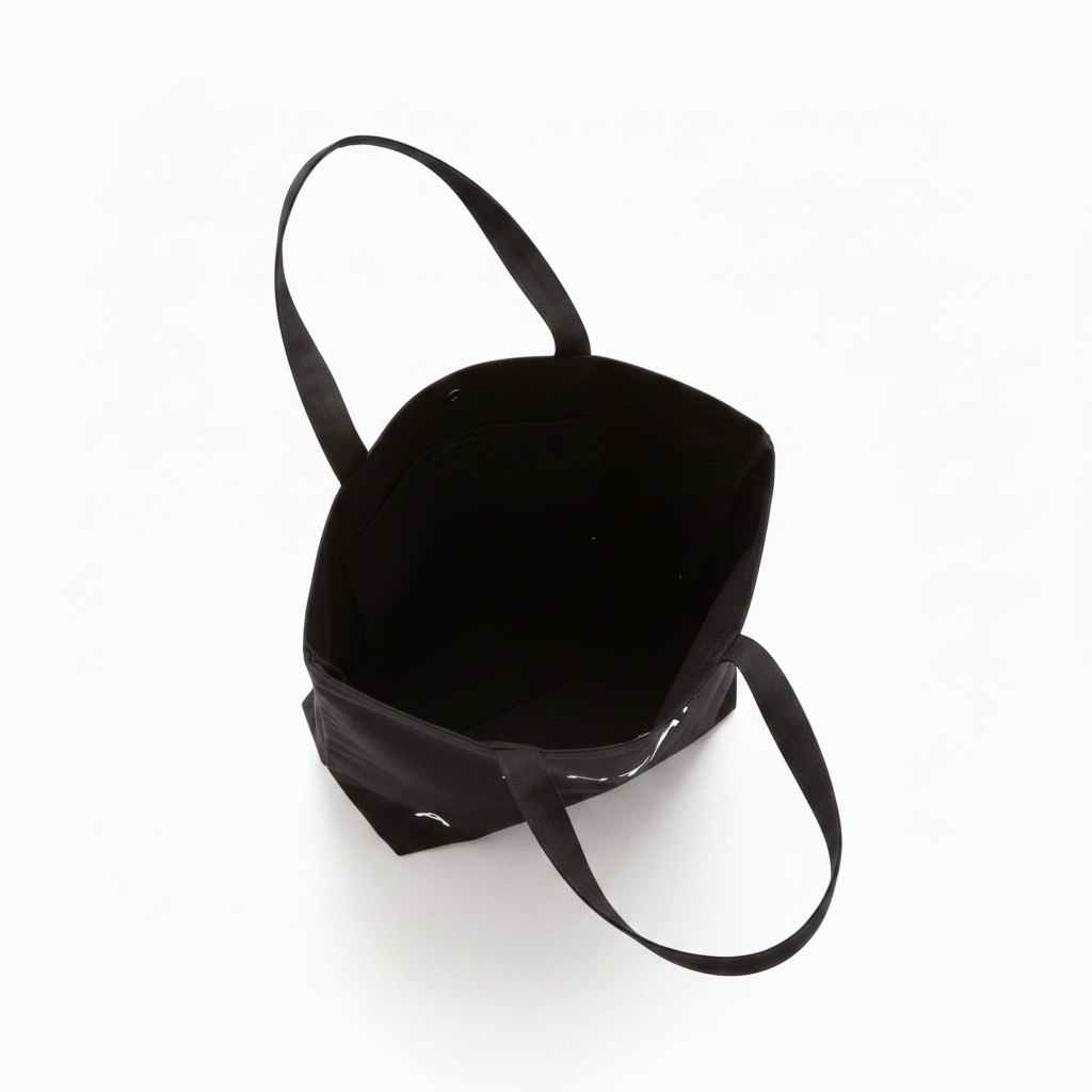 A black fabric tote bag with long shoulder straps, shown from an overhead angle on a clean white background.